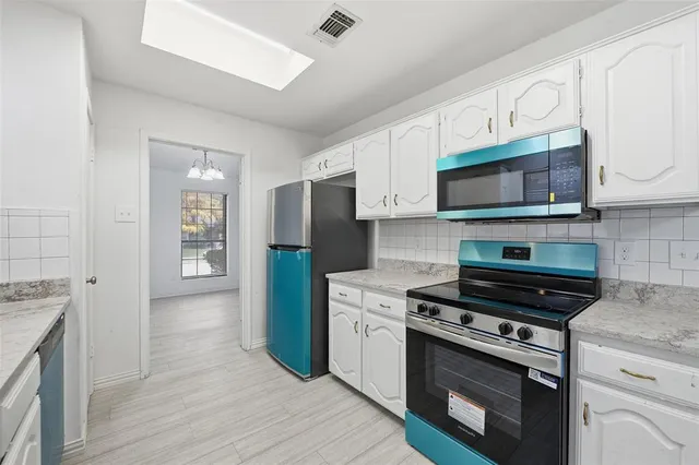a kitchen with stainless steel appliances a stove a microwave and cabinets