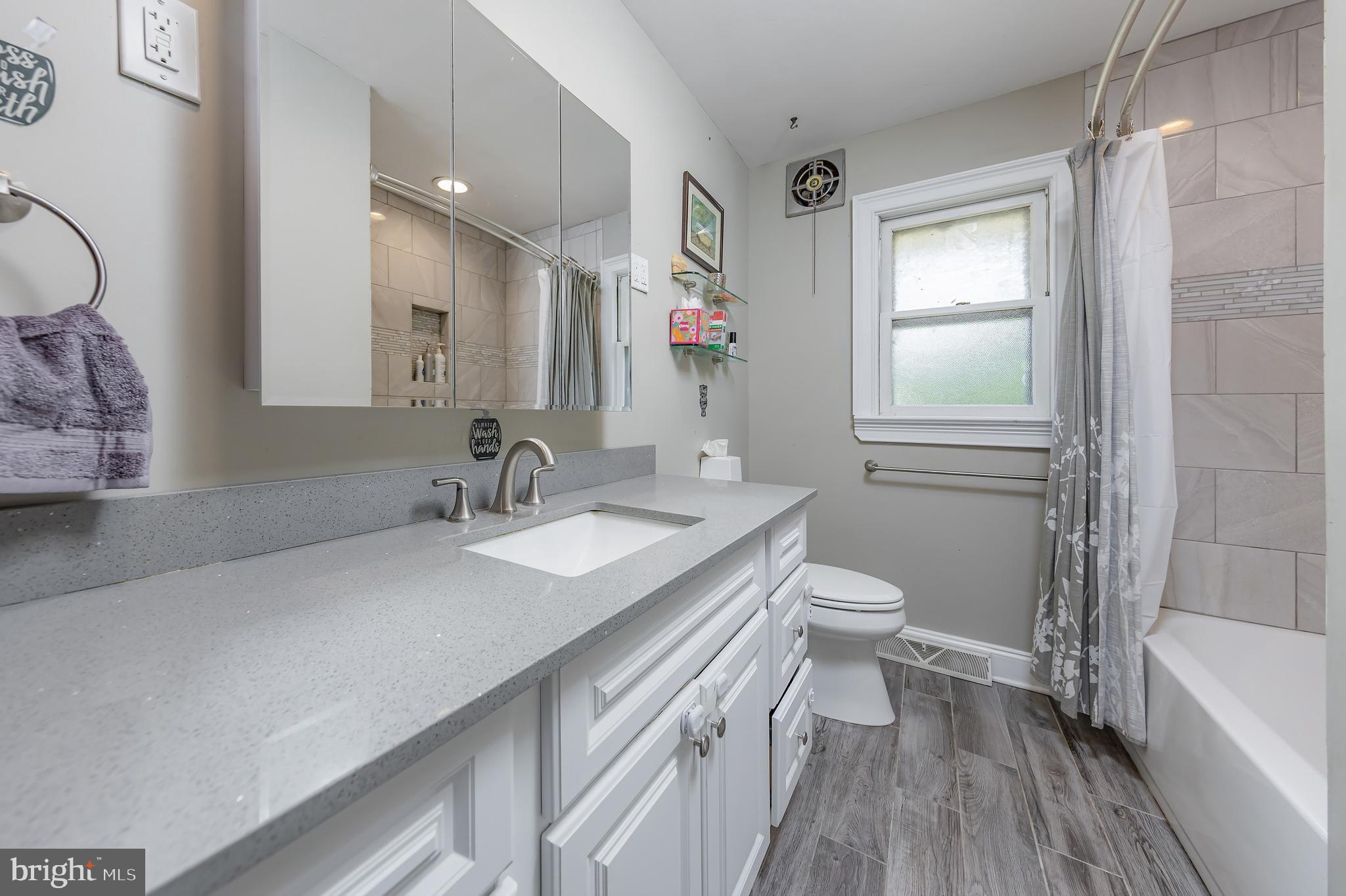 121 Kansas Road Pennsville, NJ 08070 - Photo 11 of 32 a bathroom with a granite countertop sink a toilet and shower