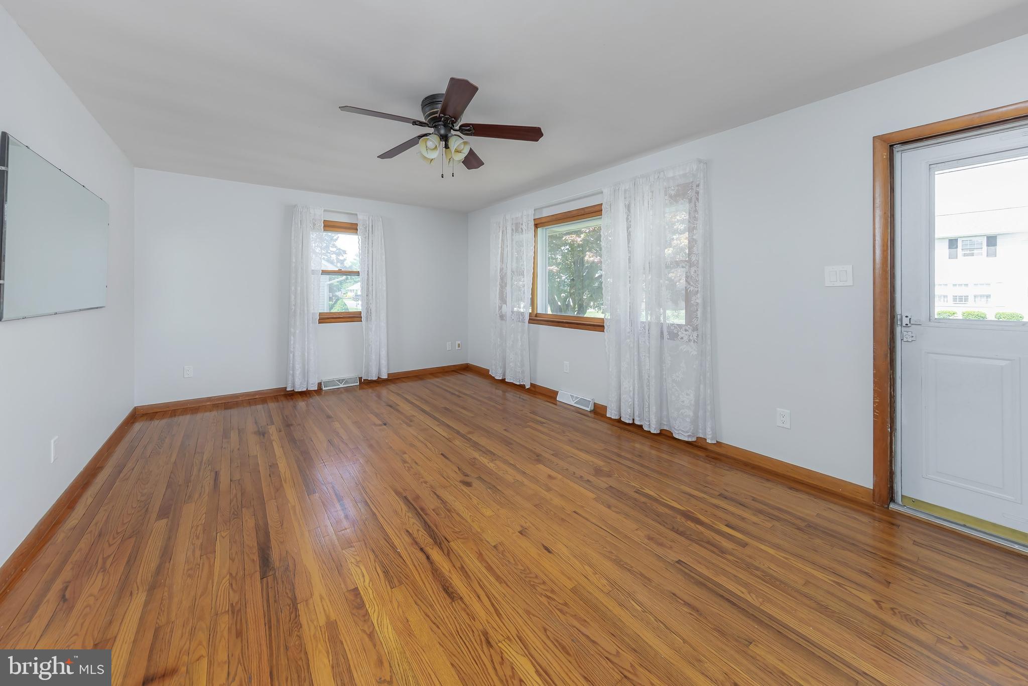 121 Kansas Road Pennsville, NJ 08070 - Photo 4 of 32 a view of empty room with wooden floor and fan