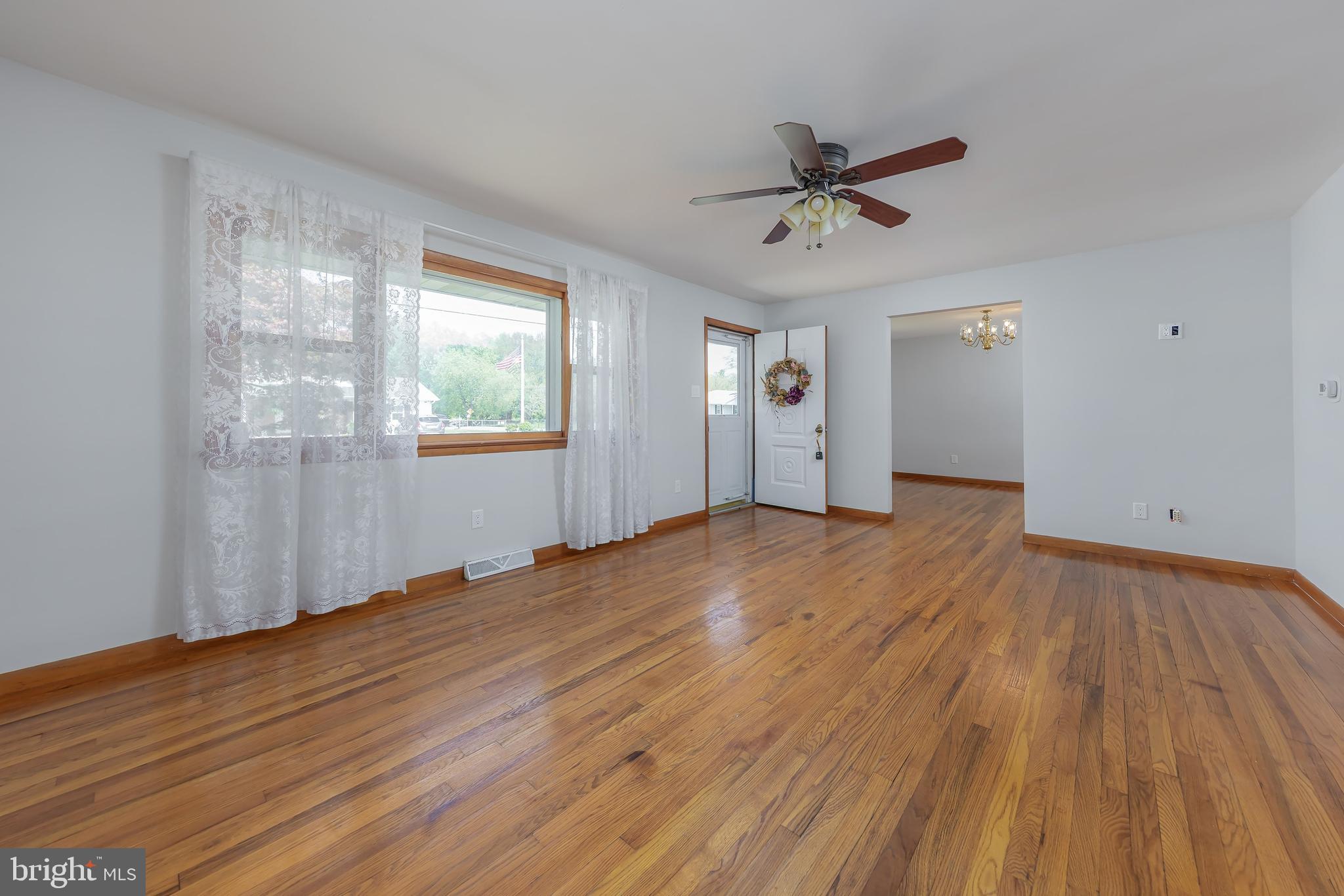 121 Kansas Road Pennsville, NJ 08070 - Photo 5 of 32 a view of empty room with wooden floor and fan