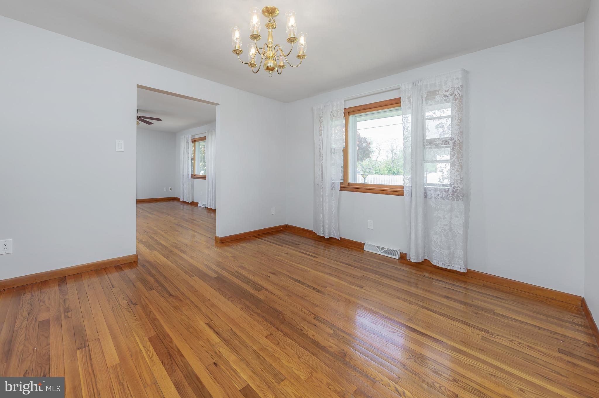 121 Kansas Road Pennsville, NJ 08070 - Photo 6 of 32 a view of an empty room with wooden floor and a window