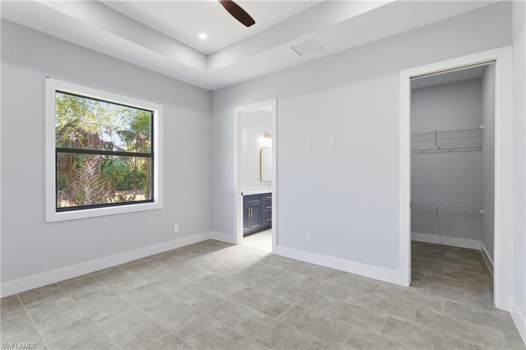19871 Adams Road Fort Myers, FL 33908 - Photo 12 of 25 Unfurnished bedroom with ensuite bathroom, a spacious closet, a ceiling fan, and recessed lighting
