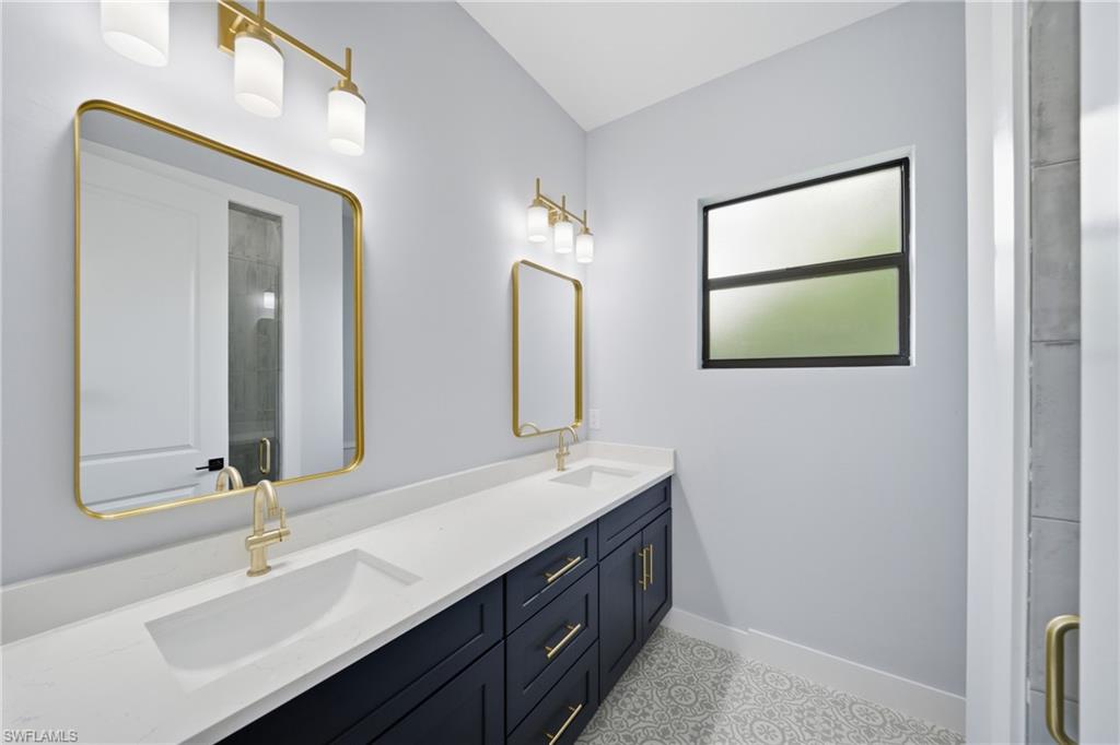 19871 Adams Road Fort Myers, FL 33908 - Photo 13 of 25 Bathroom featuring double vanity and a shower stall