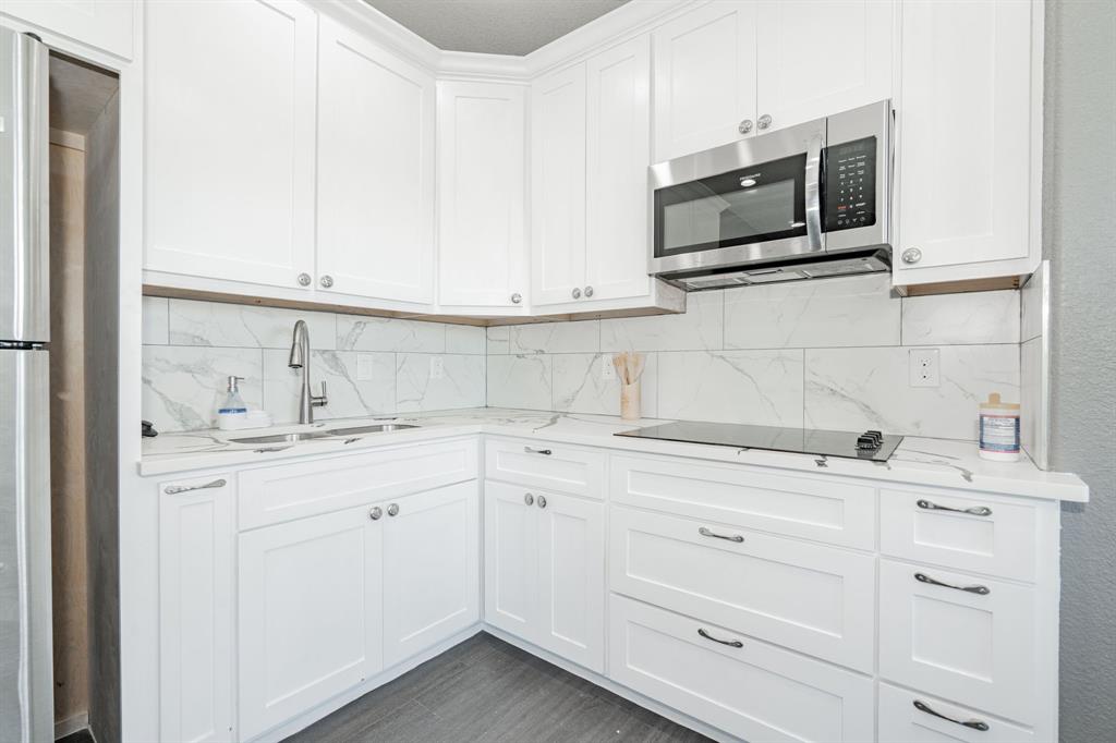 641 Countess Road Quinlan, TX 75474 - Photo 5 of 35 a kitchen with granite countertop white cabinets stainless steel appliances and a sink