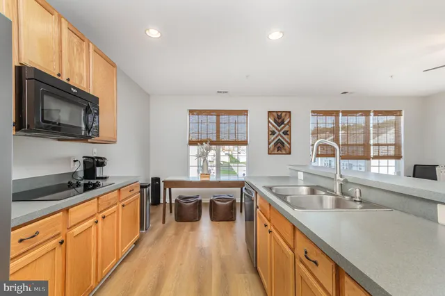a large kitchen with stainless steel appliances a large window in it