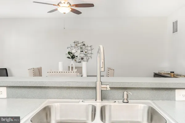 a kitchen with stainless steel appliances granite countertop a sink a stove and a wooden cabinets