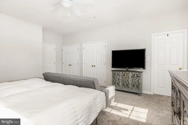 a large white bed sitting in a bedroom and a flat tv screen