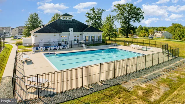an aerial view of a house with swimming pool and furniture