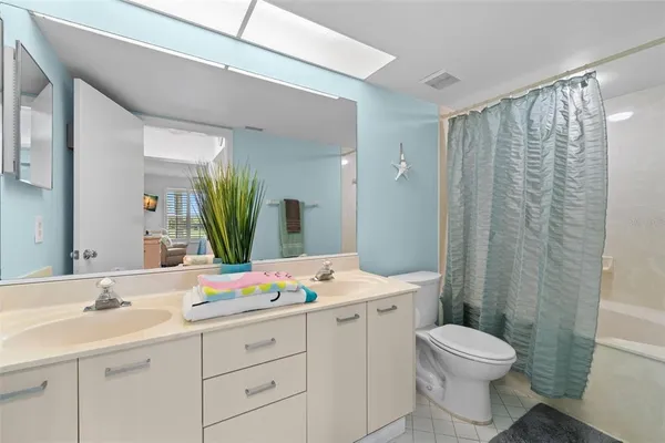 a bathroom with a double vanity sink toilet and shower