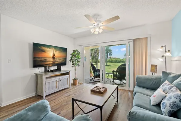 a living room with furniture a flat screen tv and a large window