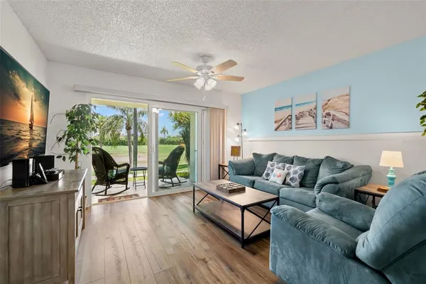 a living room with furniture large windows and flat screen tv