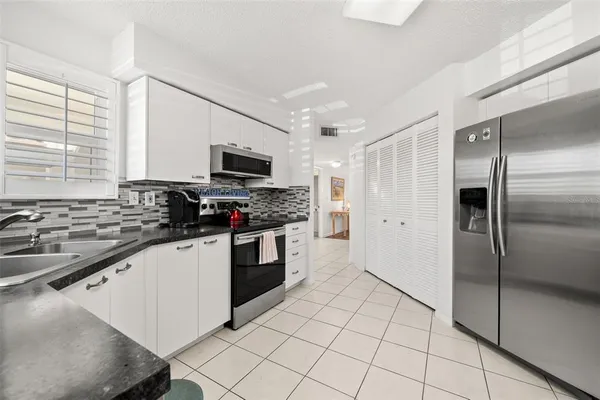 a kitchen with granite countertop a refrigerator and a sink