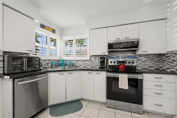 a kitchen with granite countertop a sink and steel appliances