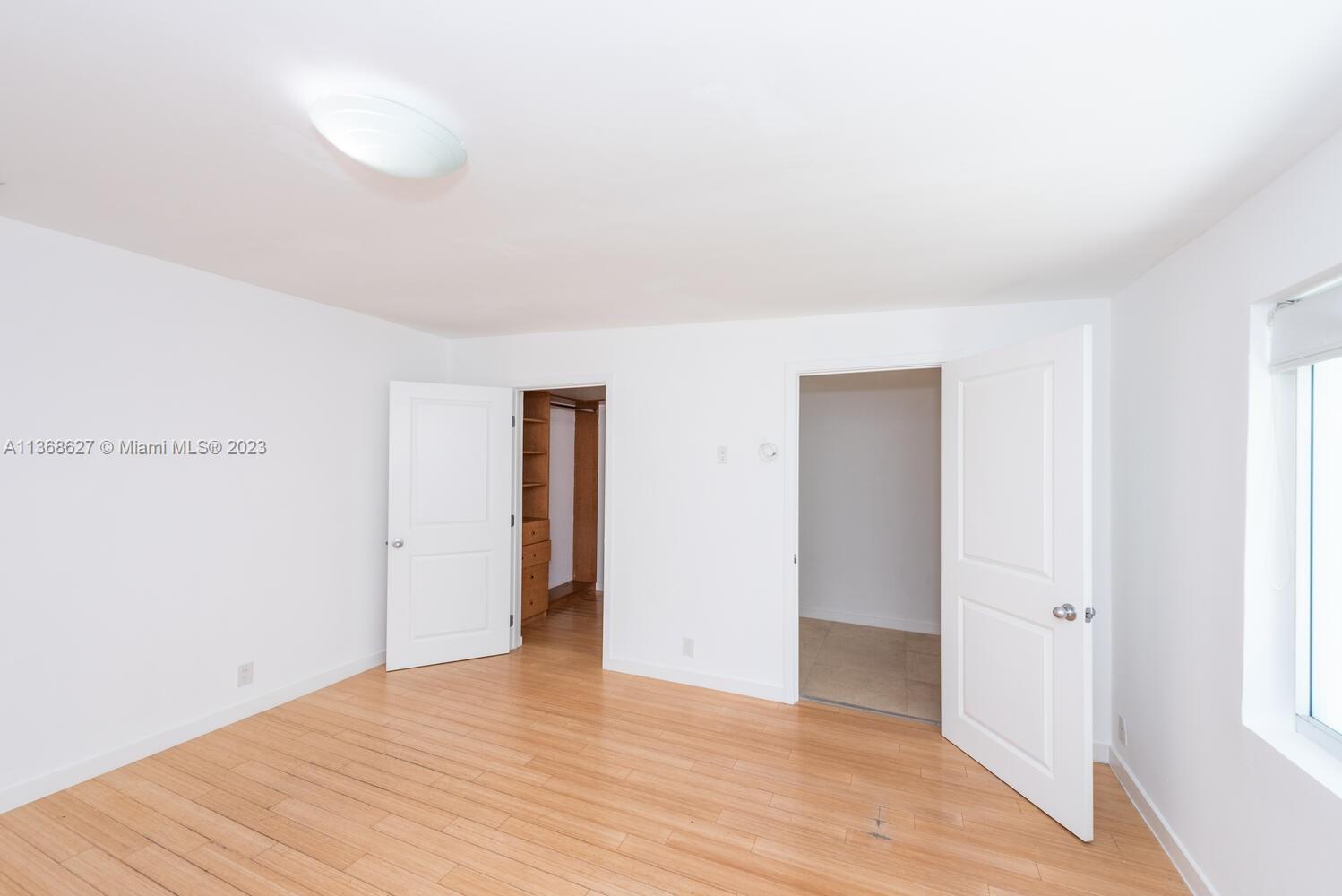265 Ridgewood Road Key Biscayne, FL 33149 - Photo 18 of 25 a view of an empty room with wooden floor and a window
