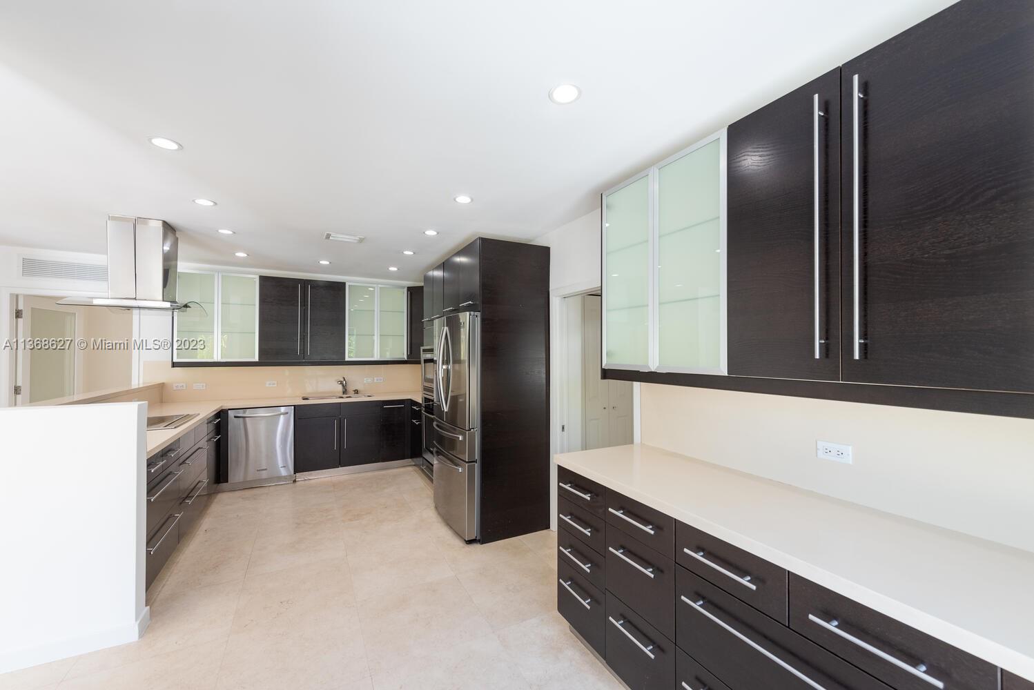 265 Ridgewood Road Key Biscayne, FL 33149 - Photo 6 of 25 a kitchen with stainless steel appliances kitchen island granite countertop a refrigerator and a sink