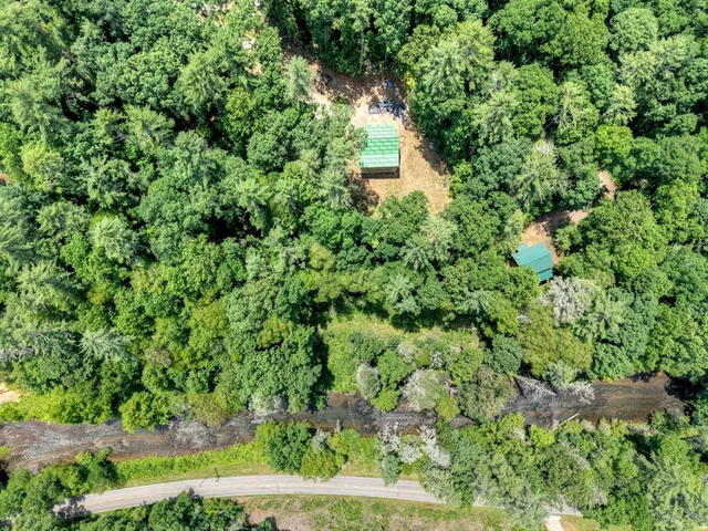 a view of a house with a yard and wooden fence