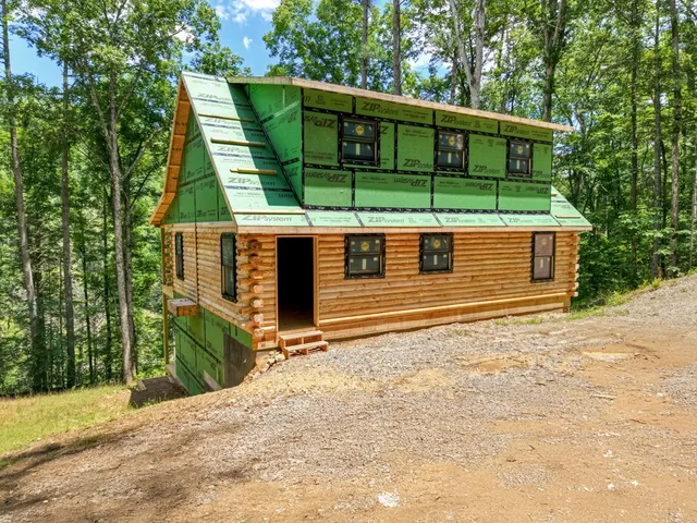 a backyard of a house with wooden fence and large trees