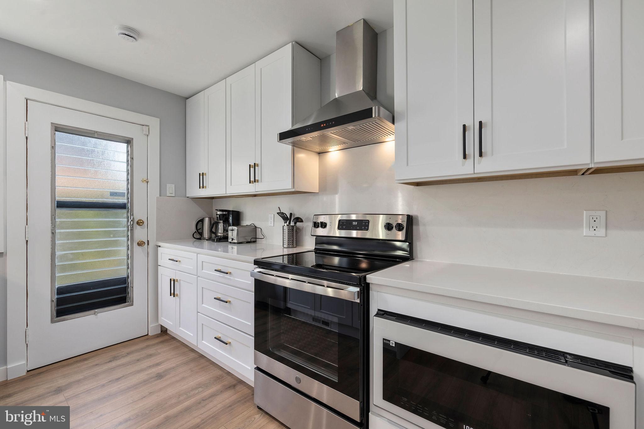 2209 Ellis Street Silver Spring, MD 20910 - Photo 12 of 49 a kitchen with white cabinets and appliances
