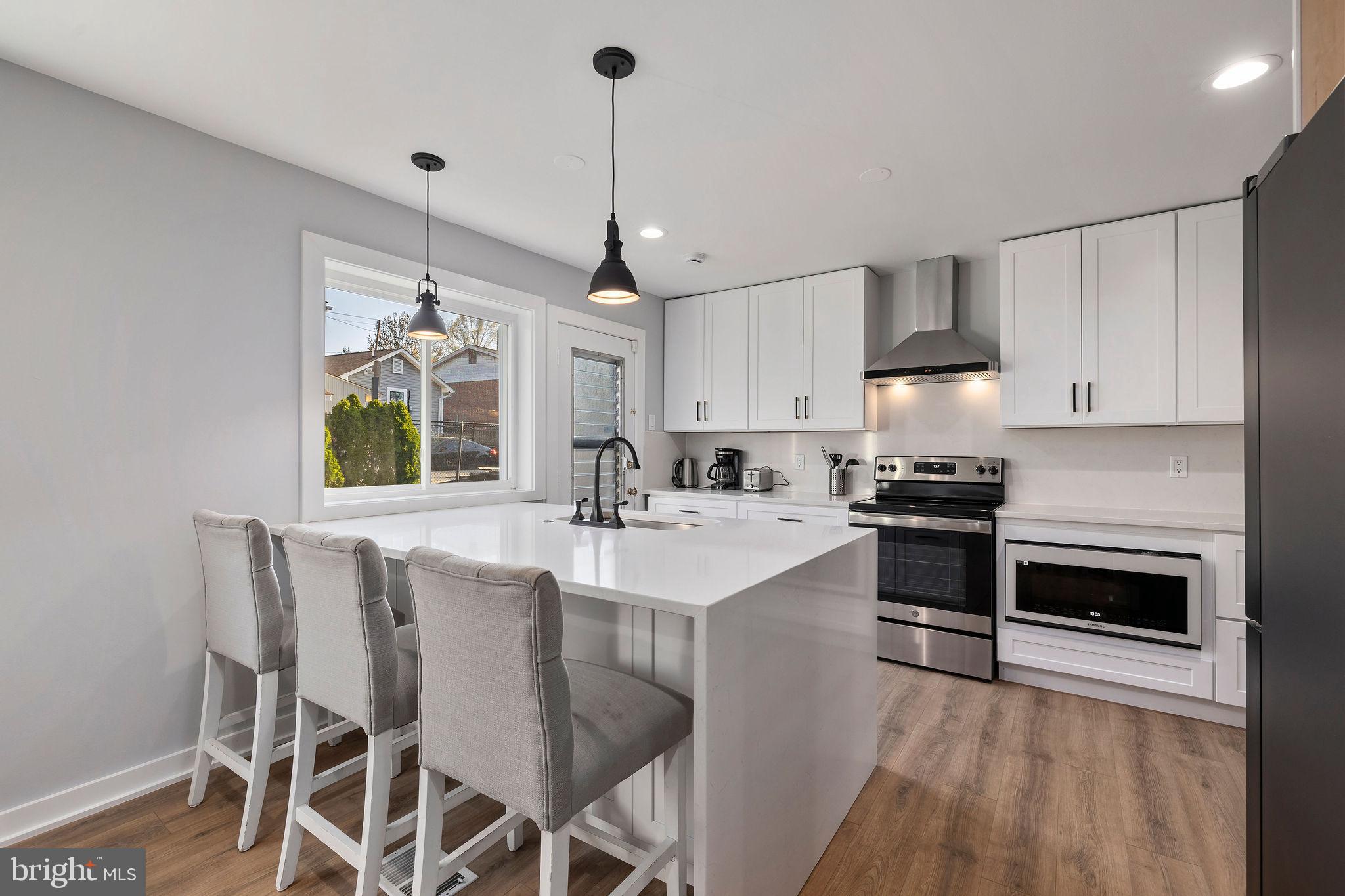 2209 Ellis Street Silver Spring, MD 20910 - Photo 10 of 49 a kitchen with stainless steel appliances a stove a sink a window and chairs