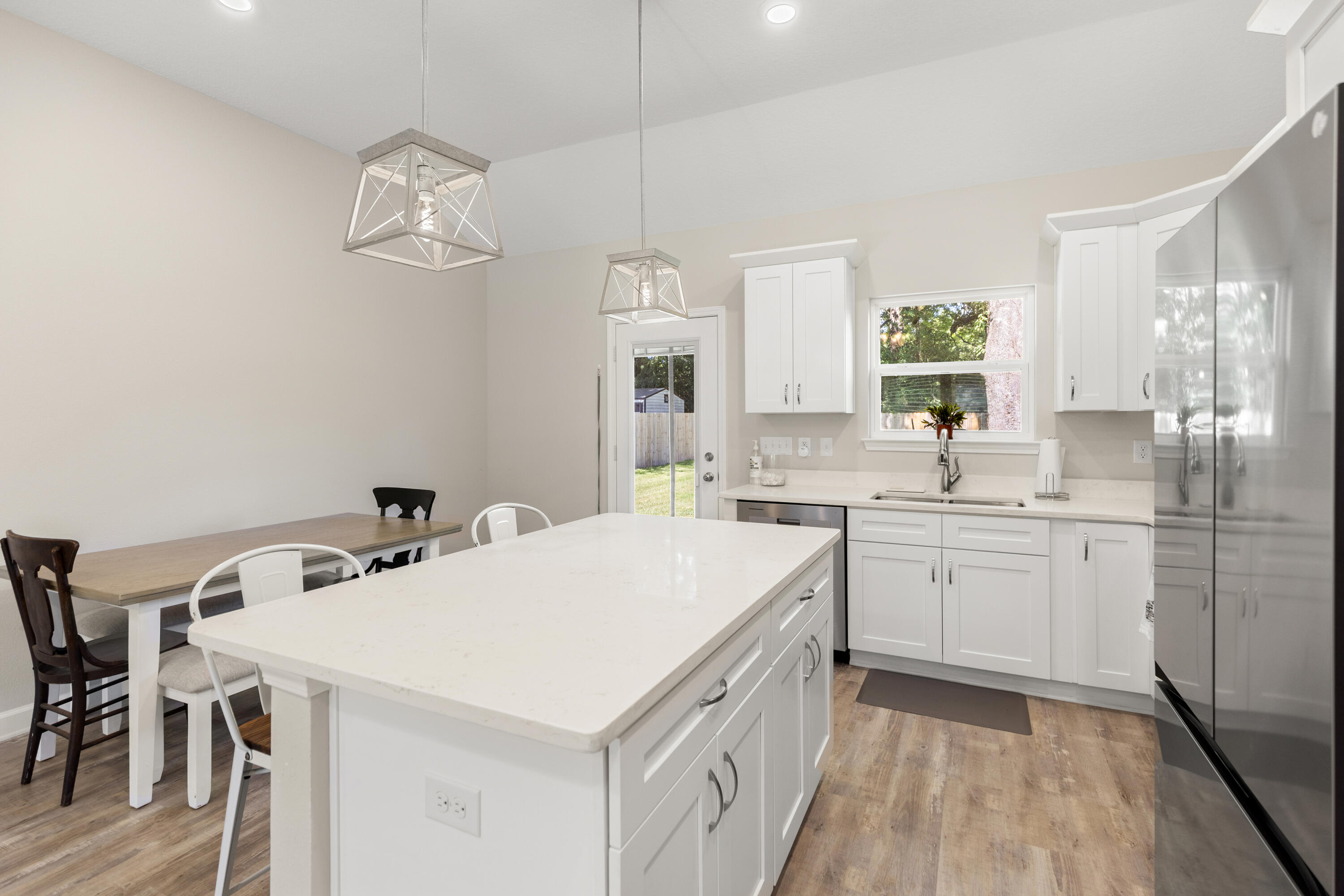 135 Shady Lane Crestview, FL 32536 - Photo 11 of 36 a kitchen with a sink a stove a refrigerator and white cabinets
