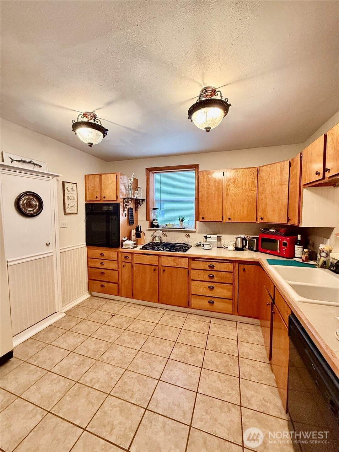 213 East Oak Street Dayton, WA 99328 - Photo 12 of 27 a large kitchen with stainless steel appliances a stove a sink dishwasher and a refrigerator with wooden floor