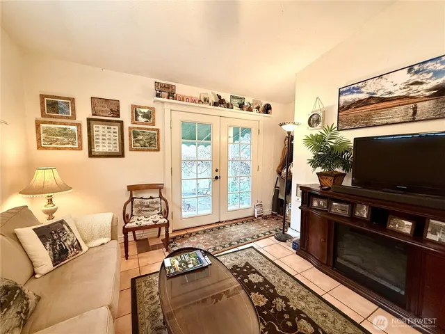 a living room with furniture a flat screen tv and a floor to ceiling window