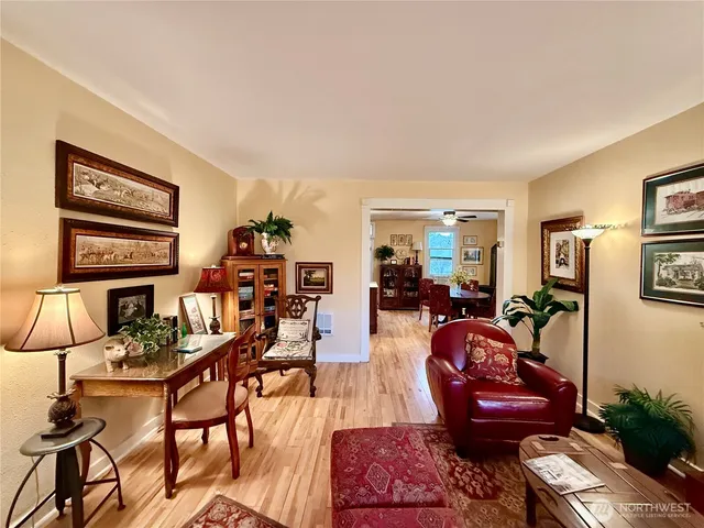 a living room with furniture a wooden floor and next to a window