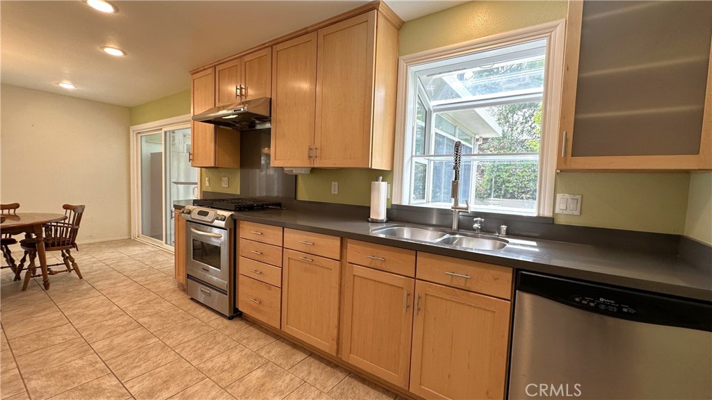 12111 Eddleston Drive Porter Ranch, CA 91326 - Photo 11 of 31 a kitchen with stainless steel appliances granite countertop a sink stove and cabinets