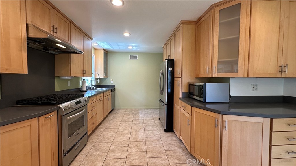 12111 Eddleston Drive Porter Ranch, CA 91326 - Photo 9 of 31 a kitchen with stainless steel appliances granite countertop a sink and a stove