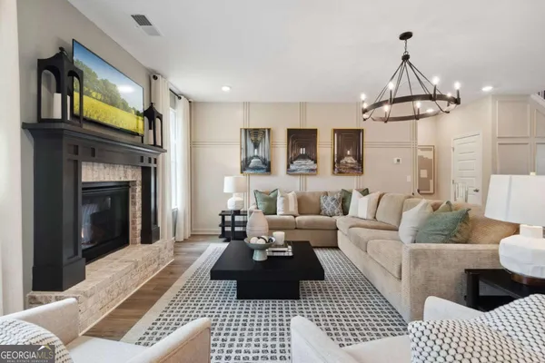 a kitchen with stainless steel appliances a dining table chairs refrigerator and microwave