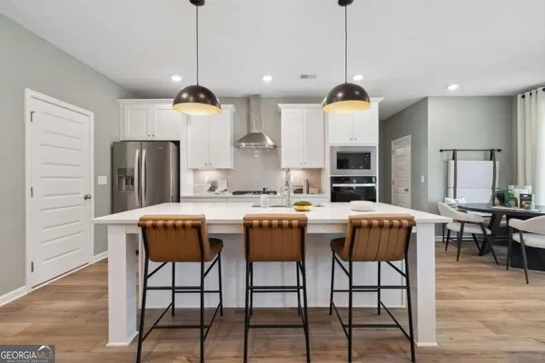 a kitchen with a table chairs refrigerator and microwave