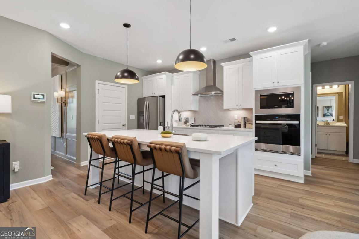 108 Compass Road Hampton, GA 30228 - Photo 20 of 51 a kitchen with a table chairs refrigerator and microwave