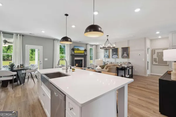 a large kitchen with kitchen island stainless steel appliances a stove center island and living room view