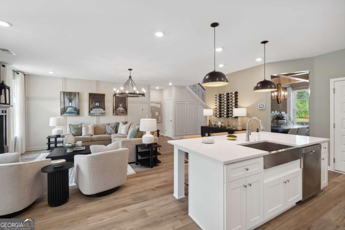 108 Compass Road Hampton, GA 30228 - Photo 26 of 51 a large kitchen with kitchen island stainless steel appliances a stove center island and living room view