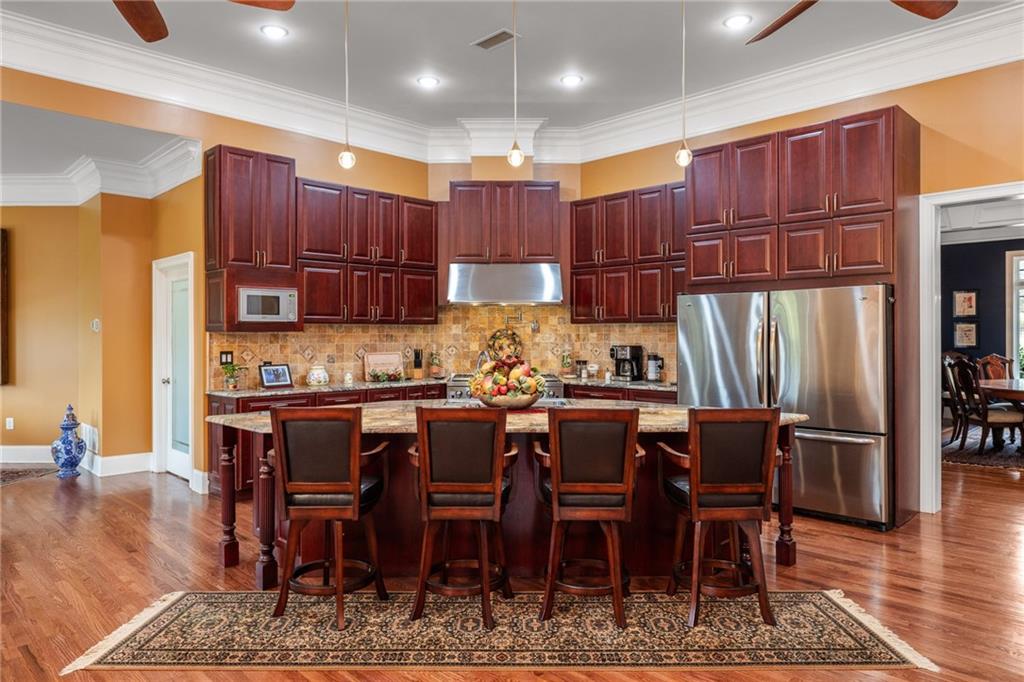 265 Honeysuckle Lane Temple, GA 30179 - Photo 13 of 45 a kitchen with stainless steel appliances wooden cabinets dining table and chairs