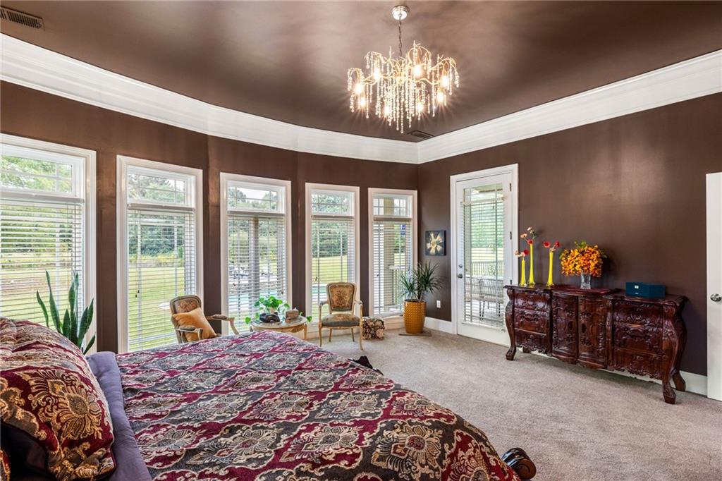 265 Honeysuckle Lane Temple, GA 30179 - Photo 20 of 45 a bedroom with a large bed and a chandelier