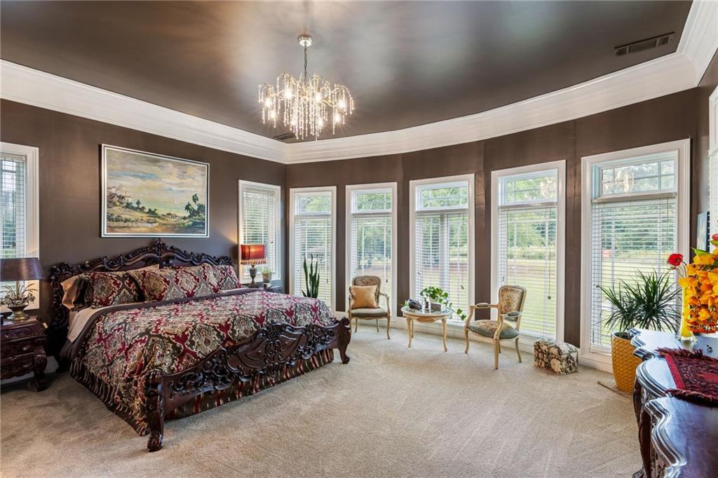 265 Honeysuckle Lane Temple, GA 30179 - Photo 4 of 5 a spacious bedroom with large bed and a chandelier