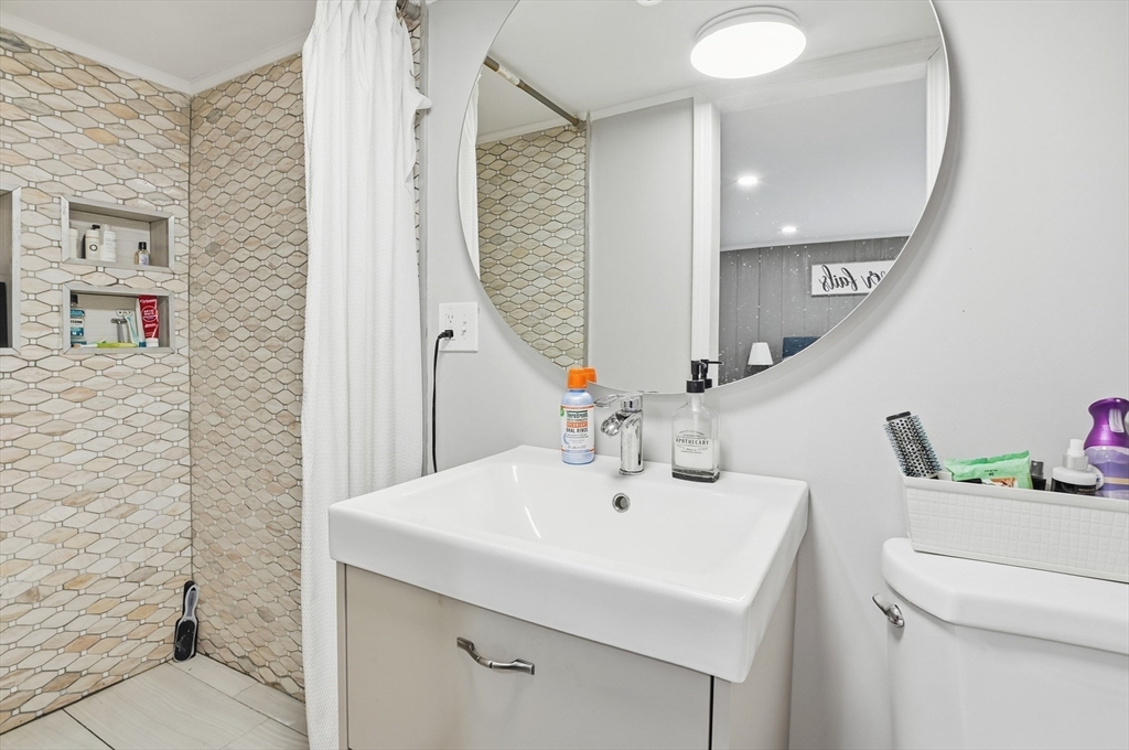 165 Turnpike Road, Unit 7 Westborough, MA 01581 - Photo 14 of 19 a bathroom with a sink vanity and a mirror