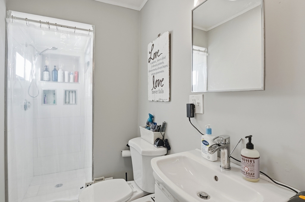 165 Turnpike Road, Unit 7 Westborough, MA 01581 - Photo 17 of 19 a bathroom with a sink mirror and a toilet