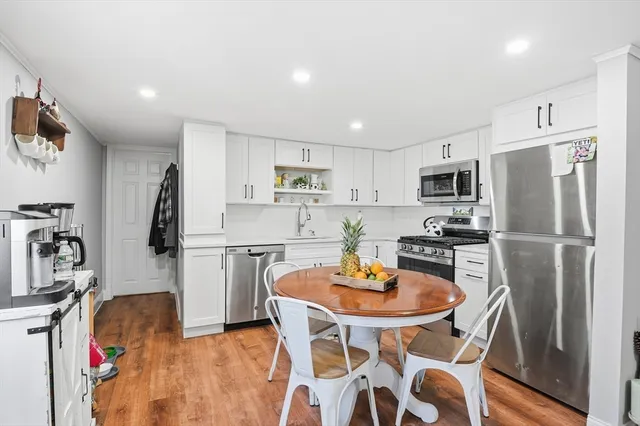a kitchen with a refrigerator a stove a dining table and chairs
