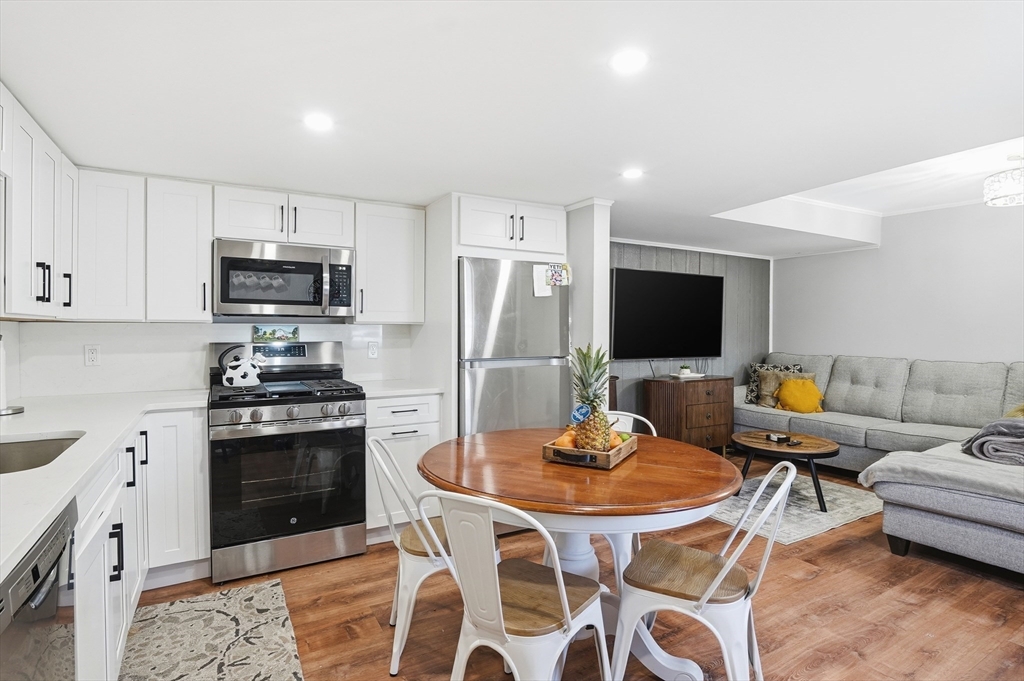 165 Turnpike Road, Unit 7 Westborough, MA 01581 - Photo 9 of 19 a kitchen with stainless steel appliances a stove a sink a microwave a refrigerator a stove a dining table and chairs