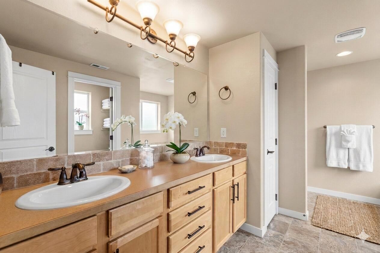 2781 Northeast Spring Water Place Bend, OR 97701 - Photo 9 of 23 a bathroom with a granite countertop double vanity sink a mirror a vanity and a shower