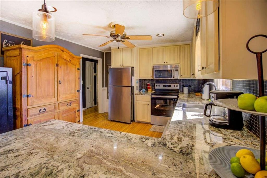 40 Spillers Lane Covington, GA 30014 - Photo 13 of 42 a living room with stainless steel appliances kitchen island granite countertop furniture and a wooden floor