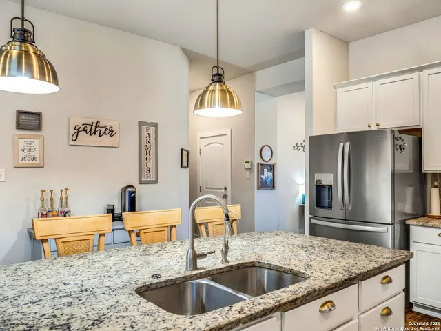 a kitchen with stainless steel appliances granite countertop a sink a refrigerator and a granite counter tops
