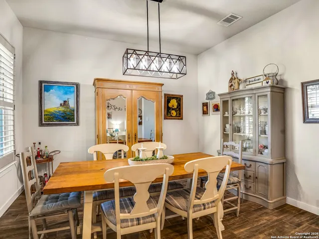a view of a dining room with furniture a chandelier and wooden floor