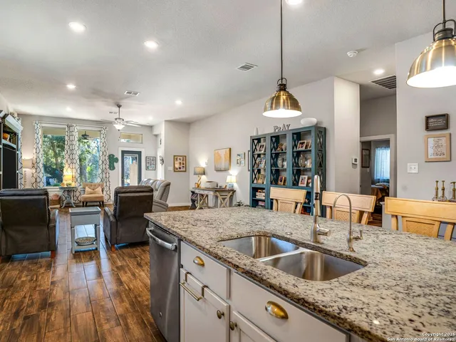 a kitchen with granite countertop a sink stove and wooden floor