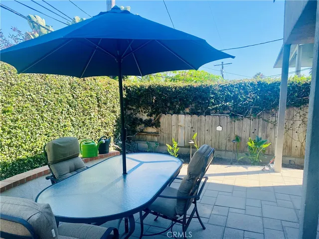 a patio with a table and chairs under an umbrella