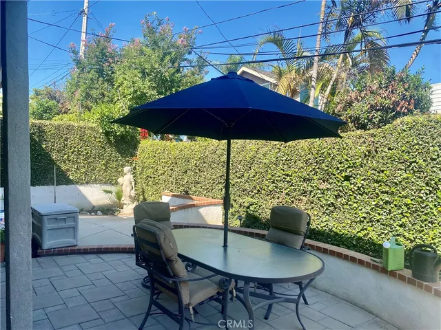 a patio with a table and chairs under an umbrella