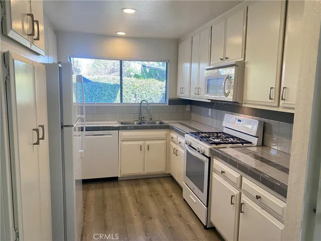 a kitchen with a stove a sink and a window