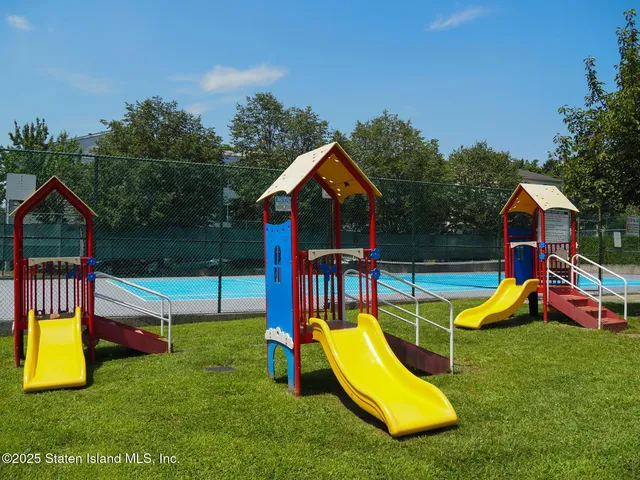 a view of swimming pool with outdoor seating and trees in the background